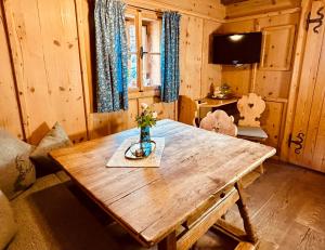 a living room with a wooden table in a cabin at Urige Kuschelhütten Oberprenner in Haus im Ennstal