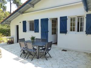patio ze stołem i krzesłami przed domem w obiekcie Villa LA TEIGNOUSE entre lac et océan terrasse et jardinet pour 6 personnes w mieście Soorts-Hossegor