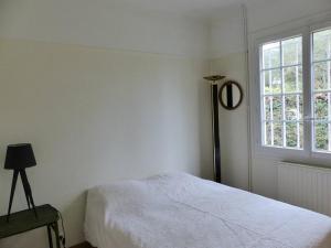 biała sypialnia z łóżkiem i oknem w obiekcie Villa LA TEIGNOUSE entre lac et océan terrasse et jardinet pour 6 personnes w mieście Soorts-Hossegor