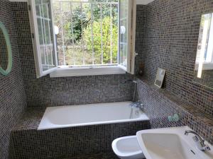 łazienka z wanną, umywalką i oknem w obiekcie Villa LA TEIGNOUSE entre lac et océan terrasse et jardinet pour 6 personnes w mieście Soorts-Hossegor +10 zdjęć