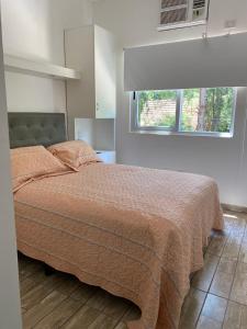 a bedroom with a bed with a blanket and a window at Casa de Huespedes Guacaras in Santa Ana +16 photos