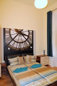 ブダペストにあるFrank & Fang Apartmentsのベッドルーム1室(大型ベッド1台、壁に大きな時計付)