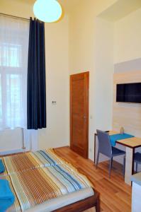 ブダペストにあるFrank & Fang Apartmentsのベッドルーム1室(ベッド1台、テーブル付)