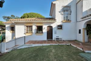 una casa blanca con una puerta y un patio en Bonita casa adosada en esquina, en Marbella