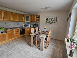 a kitchen with a table and chairs in a room at Ferienwohnung im Alpenvorland am Lech in Apfeldorf
