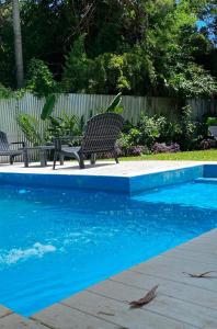 a bench sitting next to a blue swimming pool at Casa de Huespedes Guacaras in Santa Ana