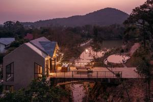 a house with a bridge over a river at Quin home, into the forest, close to Noi Bai airport in Phú Hữu