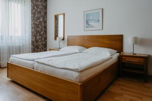 un grande letto in una camera da letto con due comodini e due lampade di Winzerhof Michael Gartner a Illmitz