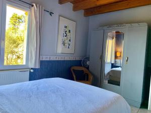 a bedroom with a bed and a window and a mirror at Maison de charme à Saint-Géry avec piscine partagée in Saint-Géry +25 photos