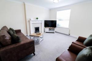 a living room with two couches and a television at 3br House With Parking Near Iron Pier Thames River in Woolwich