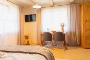 a bedroom with a bed and a table and chairs at Rustic Inn bed and breakfast in Budeşti