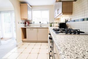 a kitchen with white cabinets and a counter top at 3br House With Parking Near Iron Pier Thames River in Woolwich +31 photos