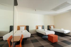 een kamer met 2 bedden en een tafel en stoelen bij easyHotel The Hague Scheveningen Beach in Scheveningen