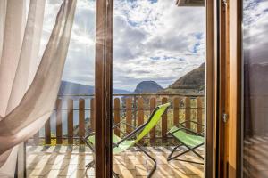a balcony with a chair and a view of the mountains at Casa Damiano in Tremosine Sul Garda