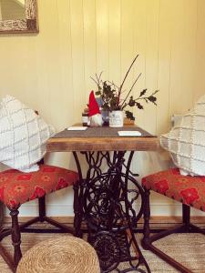 ein Tisch mit einem Santa-Hut darauf mit zwei Stühlen in der Unterkunft Ty Bach Glas in Llanhowell + 36 Fotos