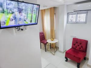 a room with a flat screen tv on a wall at Hôtel Résidence Saint James Maguerita in Douala