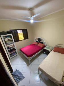 a room with a bed and a table and a window at Casa na Praia Bertioga in Bertioga
