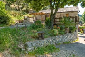ein Haus mit einer Steinmauer und einem Garten in der Unterkunft Gîte Gîtes de France 4/6 personnes à Campéménard in Sainte-Croix-Vallée-Française