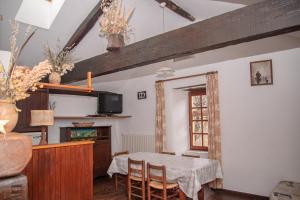 ein Esszimmer mit Tisch und Fernseher in der Unterkunft Gîte Gîtes de France 4/6 personnes à Campéménard in Sainte-Croix-Vallée-Française