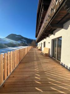 a wooden walkway next to a building next to the ocean at Wolter Landhaus in Vipiteno