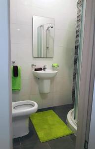 Un baño con inodoro, lavabo y espejo. en Spacious Depiro Apartment Sliema, en Sliema