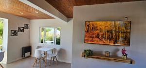 a dining room with a table and a painting on the wall at Hostel Aonikenk in El Calafate