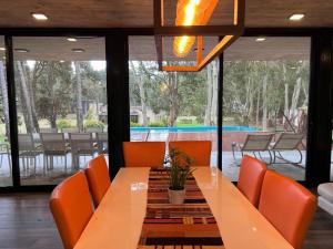 a dining room with a table and orange chairs at Casa de lujo en Costa Esmeralda in Costa Esmeralda