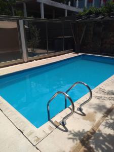 a blue swimming pool with a metal rail in a building at Pauvalén Departamentos in Potrero de los Funes