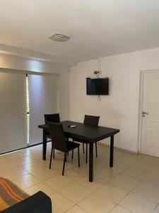 a dining room with a black table and chairs at Pauvalén Departamentos in Potrero de los Funes