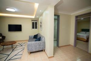 a living room with a couch and a bed at Anyiese Homes and Getaways in Kampala