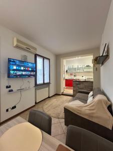 a living room with a couch and a flat screen tv at Appartamento 2 poggioli in Cremona