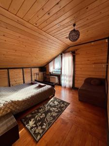 Un dormitorio con una cama en una habitación de madera. en Котедж “Гуркало", en Korchin 41 fotos más