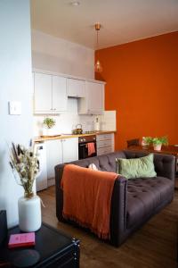 a living room with a brown couch in a kitchen at 20min train to Edinburgh, The Coorie Inn in Inverkeithing +9 photos