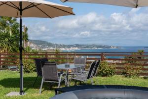 a table and chairs with an umbrella and the ocean at Sea Esta in Argassi