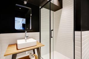 a bathroom with a sink and a glass shower at North Paris Suite in Paris +46 photos