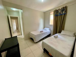 a small room with two beds and a window at Lar Botticelli 2Quartos wifi piscina ArCond in Ananindeua +28 photos