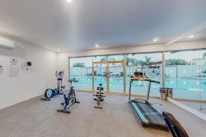 a gym with two exercise bikes and a swimming pool at Departamento C-25 in San José del Cabo