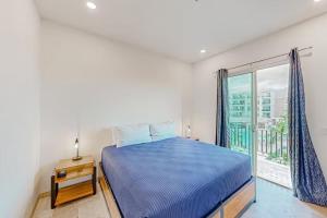 a bedroom with a blue bed and a window at Departamento C-25 in San José del Cabo +14 photos