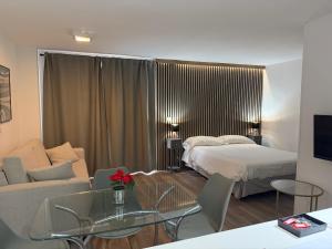 a hotel room with a bed and a couch at Estudios Suites Placentines in Seville