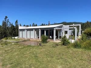 a large white house with a lot of windows at Casa de campo in De Cauquenes