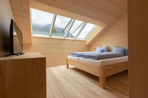 a bedroom with a bed with blue pillows and a window at Beerenhus in Au im Bregenzerwald
