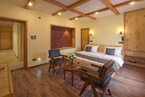 a bedroom with a bed and a table and chairs at PalPenzy - Bespoke Premium Stay in Srinagar