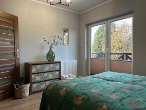 a bedroom with a bed and a vase on a dresser at Borki Guest House in Smardzewice