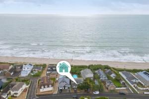 an aerial view of a house and the beach at Beachfront House w Pool & Steam in West Wittering