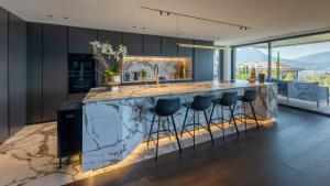 La PirrazにあるVilla Tomar - vue lacのバースツール付きの大きな大理石のカウンターを備えたキッチン