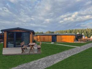 une cabine avec une table de pique-nique et des chaises dans l'herbe dans l'établissement Zacisze obok Suntago Park noclegi 2 3 6 osobowe domki, à Grabce