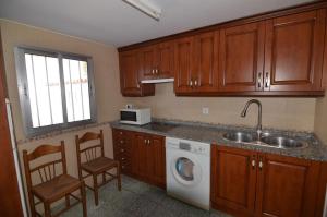 a kitchen with a sink and a washing machine at Villa de hermanos in Villardefrades