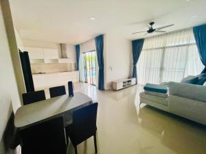 a kitchen and living room with a table and a couch at Anchan Gardens Pool Villa 23 in Hua Hin