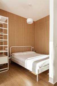 - une chambre avec un lit et un mur rayé dans l'établissement Zanella 50, à Milan