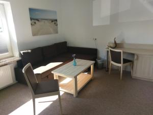 a living room with a couch and a table at Hotel Nordseegruß in Norddeich
